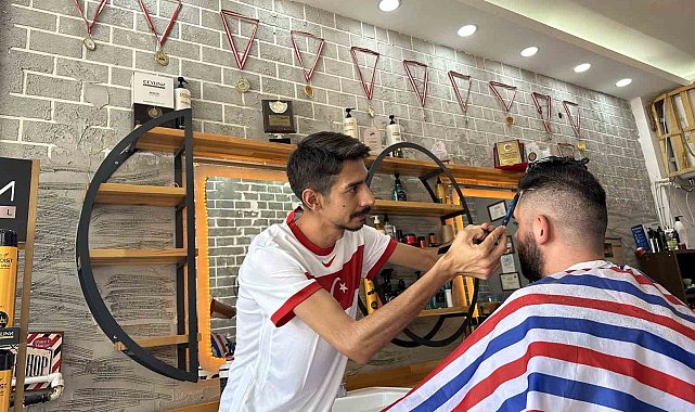 Milli maç heyecanıyla müşterilerini traş ediyor