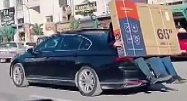 Lüks otomobilin bagajına oturan kişiler 65 inç ekran televizyonu böyle taşıdı