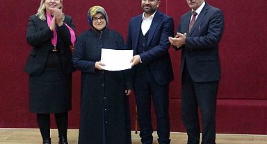 72 yaşındaki Besna Say, okur-yazarlık sertifikasını başkan oğlunun elinden aldı