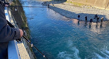 Fırtına nedeniyle balık kafesi yırtıldı, dereye doluşan somonları gören oltasını alıp dereye koştu