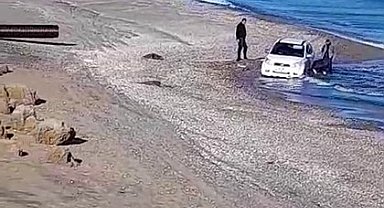 Kumsalda otomobilyle gezerken, denizde mahsur kaldı