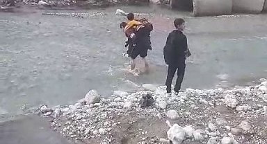 Sağanak yağışta köprü yıkıldı, öğrenciler sırtta taşındı