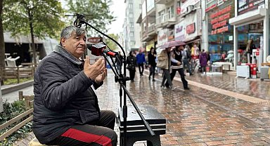 Sokaklarda her koşulda şarkı söyleyerek geçimini sağlıyor