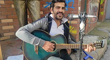 Yürüme engelli sanatçı şarkı söylemek için yaz-kış sokakta