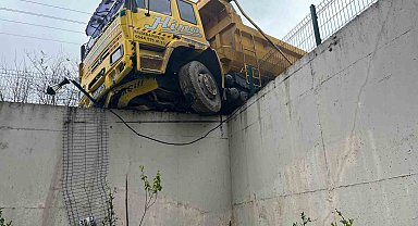 Hafriyat kamyonu istinat duvarında askıda kaldı