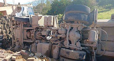 Otobüse çarpan kum yüklü kamyon, bir evin bahçesine devrildi
