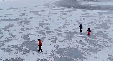 Yüzeyi donan gölün üzerinde buz pateni keyfi yaşadılar