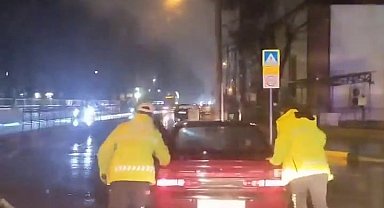 Arızalanan otomobili trafik polisleri yağmurun altında itti