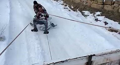 Kamyonet arkasına bağladıkları tekerlekle karda kaymanın keyfini yaşadılar
