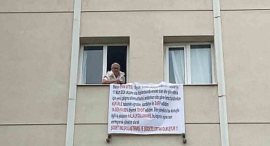 Sandalyeyle darbedilen site sakini, mağduriyetini pankartla dile getirdi