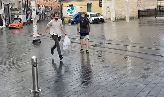 Taksim'de yağmur etkili oldu: Bir vatandaş yağmurdan kartonla korundu