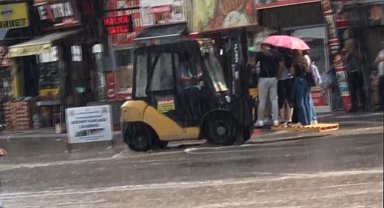 Aniden başlayan yağış sonrası yayaların imdadına belediye forkliftle yetişti