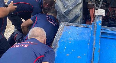 Devrilen traktörün altında kalan sürücüyü kurtarmak için zamanla yarıştılar